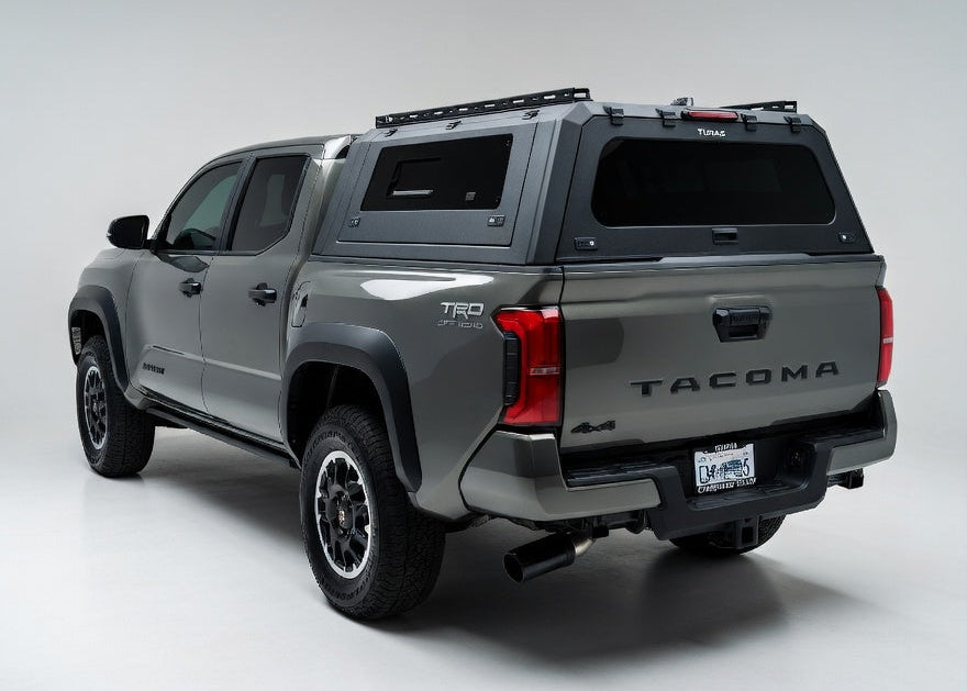 Gray Toyota Tacoma truck with a roof rack on a white background